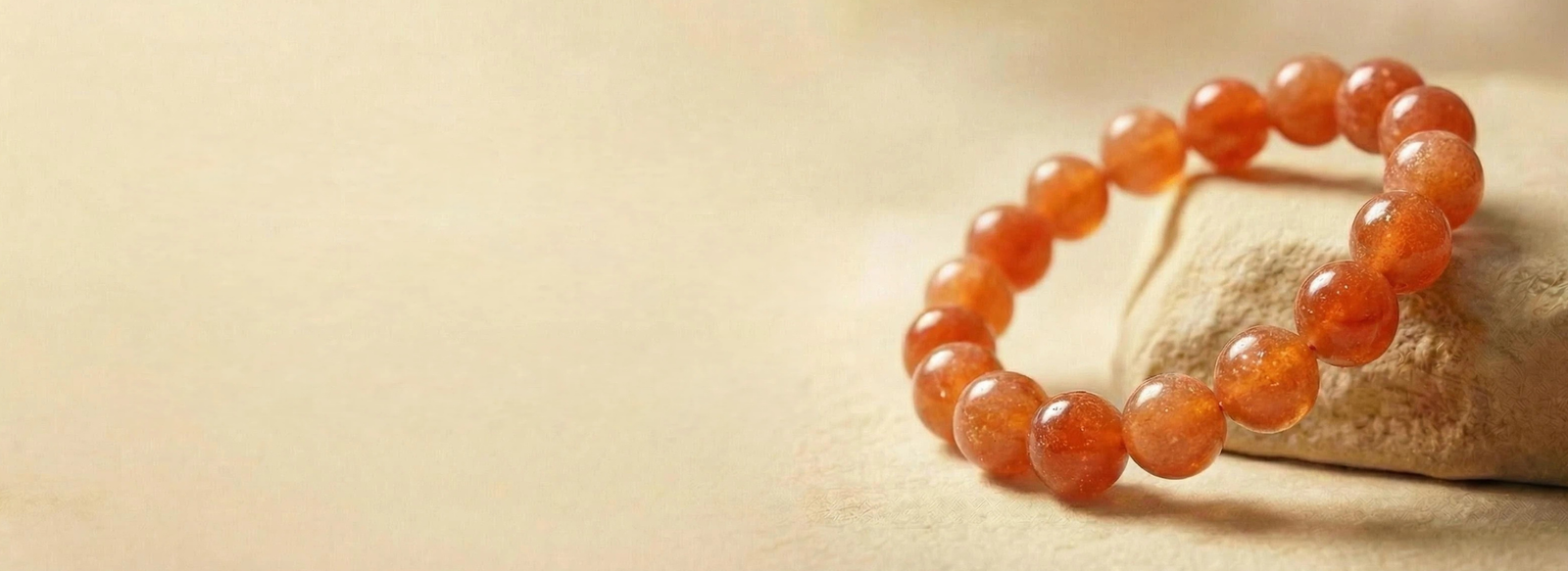 Close-up of a blessed sunstone pet memorial bracelet on a natural zen stone with warm morning light.