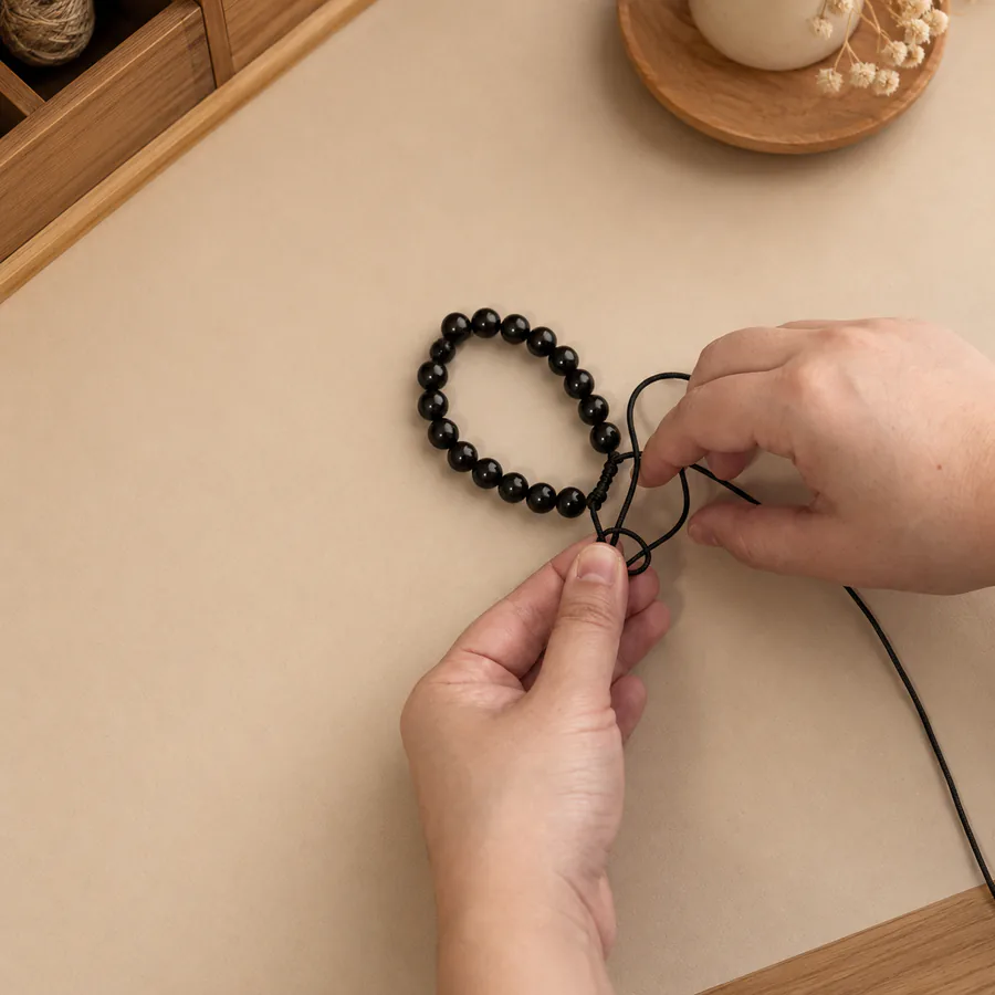 The Return Bracelet being threaded by hand in a small-batch workspace