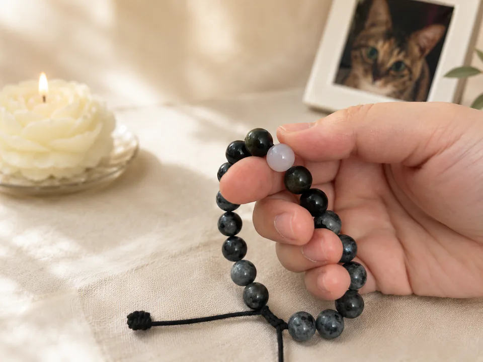 Hand touching the Moonstone Return Bead on a handmade pet remembrance bracelet